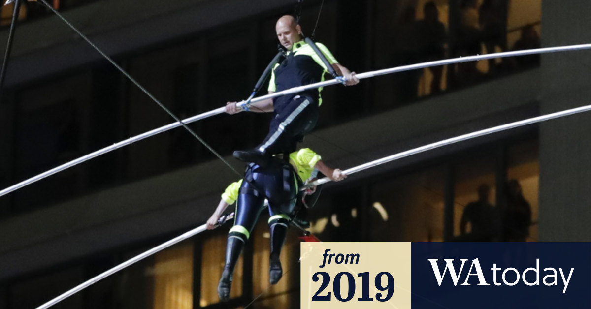 Highwire walkers safely cross Times Square 25 storeys up